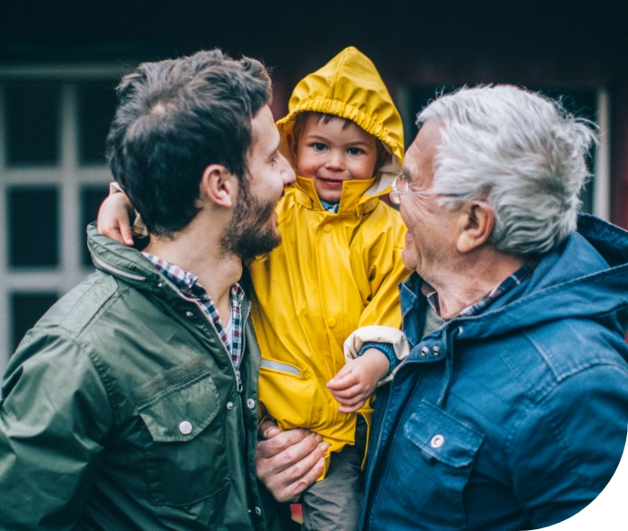 two men in coats holding a child in a coat between them